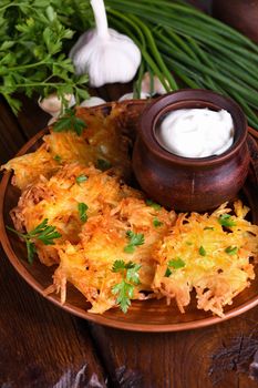 Potato fritters (a pancake, especially one made with grated potato) served with sour cream, herbs and a jug of milk. Country style.