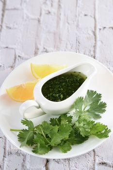 Green delicious herbal marinade of cilantro, basil, parsley, oil, traditional seasoning for salad dressing