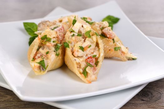 Pasta Conchiglioni stuffed with tender chicken pieces, mushrooms and vegetables in a rich creamy sauce.
