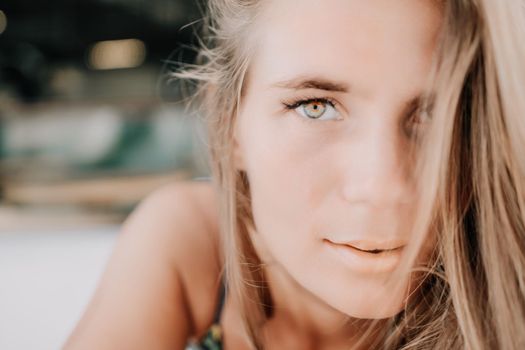 Happy woman portrait in cafe. Boho chic fashion style. Outdoor photo of young happy woman with long hair, sunny weather outdoors sitting in modern cafe