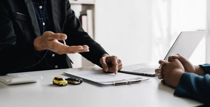 Car agent, sale man explain terms and agreement to customer before giving the car key to customer...