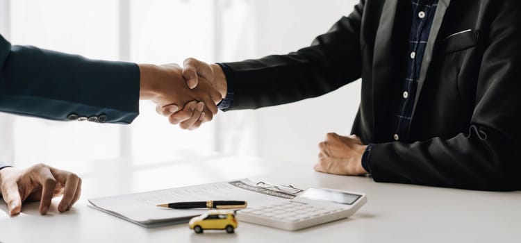 Handshake of cooperation customer and salesman after agreement, successful car loan contract buying or selling new vehicle..