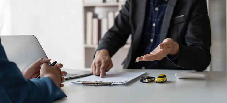 Car agent, sale man explain terms and agreement to customer before giving the car key to customer...