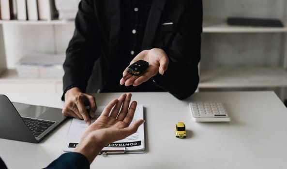 Car agent, sale man explain terms and agreement to customer before giving the car key to customer...