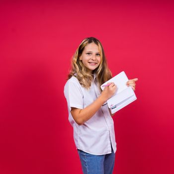 Child making notes. Kids dreams.Isolated on a red background. Education, Kid back to school.