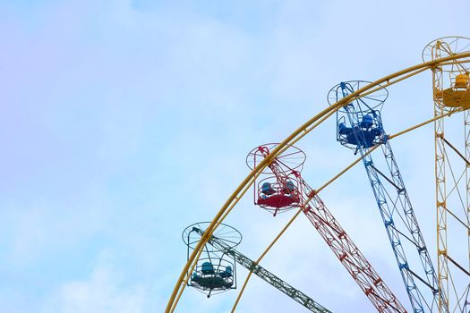 an amusement park or fairground ride consisting of a giant vertical revolving wheel with passenger cars suspended on its outer edge.