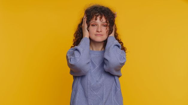 Dont want to hear and listen. Frustrated annoyed irritated curly haired woman covering ears gesturing No, avoiding advice ignoring unpleasant noise loud voices. Young girl on studio yellow background