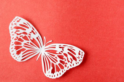Paper butterfly carve on a red background with empty space.