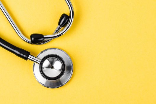 Stethoscope on yellow background with empty space for your text.