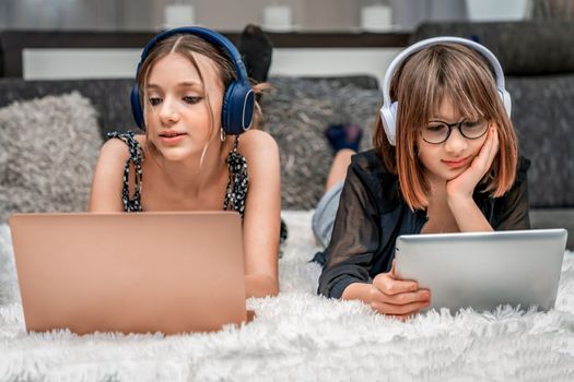 generation Z. adolescent children use modern technology at home and use headphones, laptops and tablets for entertainment and education.