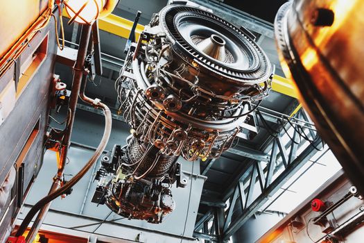 The engine of a gas turbine compressor hangs on a crane during installation in a module for generating electricity