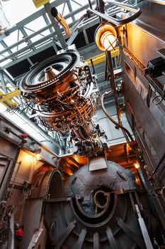 The engine of a gas turbine compressor hangs on a crane during installation in a module for generating electricity