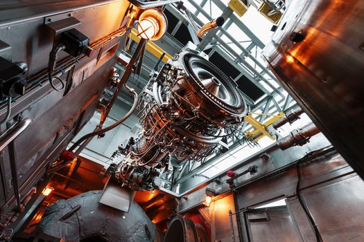 The engine of a gas turbine compressor hangs on a crane during installation in a module for generating electricity