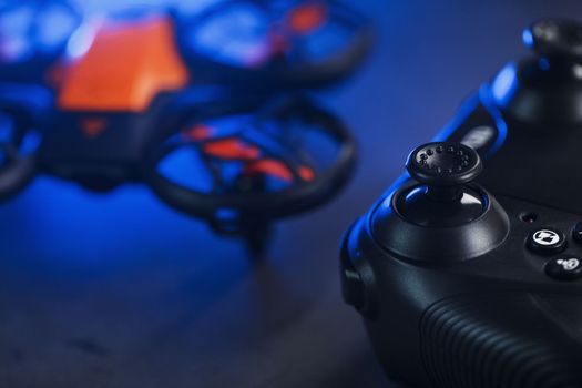 Quadcopter drone with joystick control and blue neon backlight, on a dark textured background