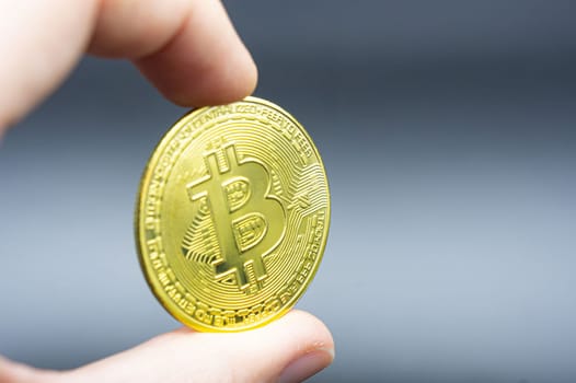 Finger hold bitcoin golden on black isolated. Hand hold gold bitcoin crypto ditital money concept. On a black background we look at a virtual currency, namely the cryptocurrency bitcoin, held in the right mine photo