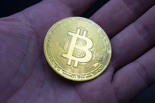 Finger hold bitcoin golden on black isolated. Hand hold gold bitcoin crypto ditital money concept. On a black background we look at a virtual currency, namely the cryptocurrency bitcoin, held in the right mine photo