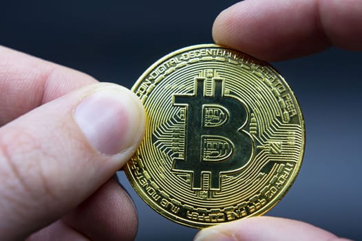 Bitcoin transfer concept from hand to hand. High quality photo. Finger hold bitcoin golden on black isolated. Hand hold gold bitcoin crypto digital money