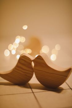 two wooden birds and heart made by bokeh lights background. Valentines day, Easter, Wedding card with wooden figures of birds, home decor.