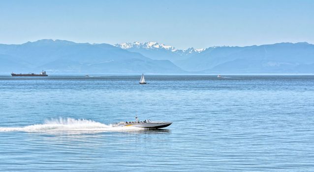Power motor boat running over the bay with tourist tour on Vancouver island