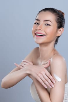 Glamorous beautiful woman applying moisturizer cream on her arm for perfect skincare treatment in isolated background. Soft makeup young girl portrait with skin rejuvenation and cosmetology concept.