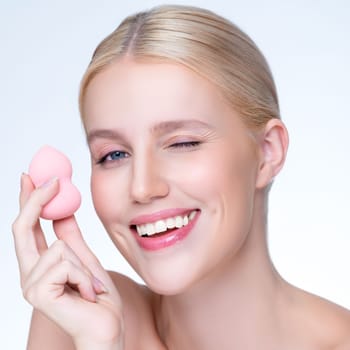 Closeup personable beautiful natural soft makeup woman using powder puff for facial makeup concept. Cushion foundation applying on young girl face in isolated background.