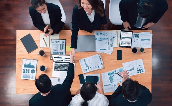 Top-view business team of financial data analysis meeting with business intelligence, report paper and dashboard on laptop for marketing strategy. Business people working together in office of harmony
