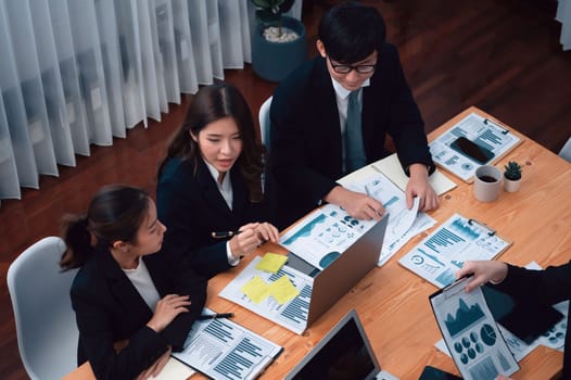 Top-view business team of financial data analysis meeting with business intelligence, report paper and dashboard on laptop for marketing strategy. Business people working together in office of harmony