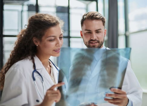 Concentrated male doctor looking at x-ray picture of spine