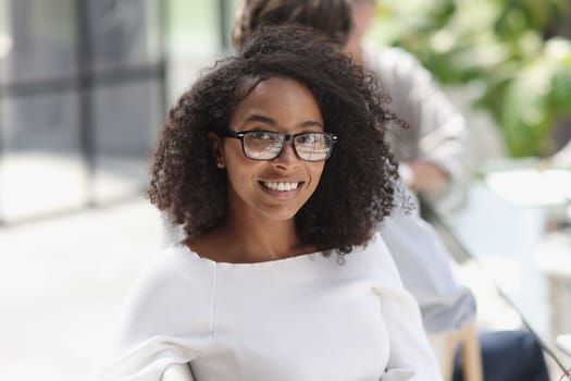 young attractive african american woman in the office sitting at the table