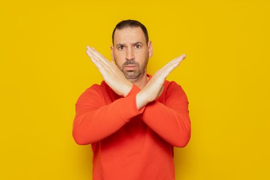 Bearded hispanic man wearing red jumper isolated keeping two arms crossed, denial concept.