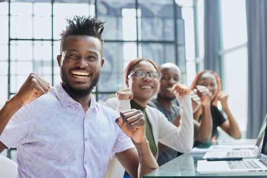 Happy young African-American man and his team in background