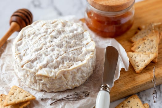 camembert soft french cheese served with liquid honey and crackers