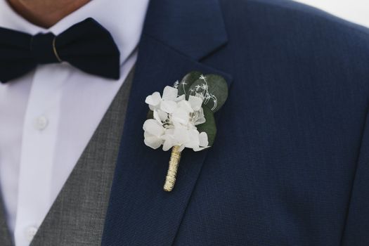 Groom with a boutonniere of white flowers