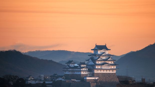 Orange sky over historic Japanese castle and Himeji landscape at sunrise. High quality photo