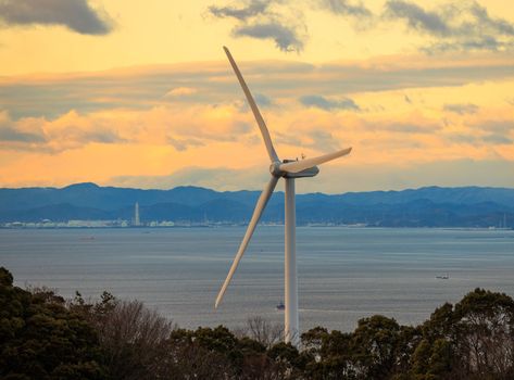 Wind Turbine Generating Clean Green Electricity on Coast at Sunset. High quality photo