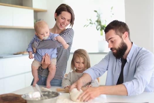 Young family with daughter and son in the kitchen