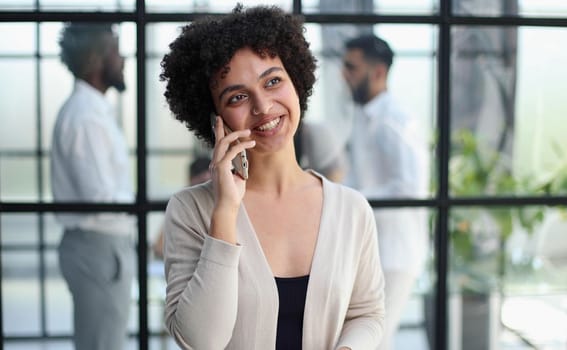 Businesswoman sitting in office, talking on the phone