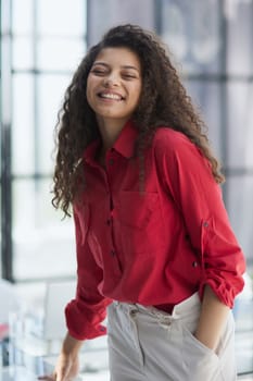 Image of young beautiful joyful woman smiling while working with laptop in office