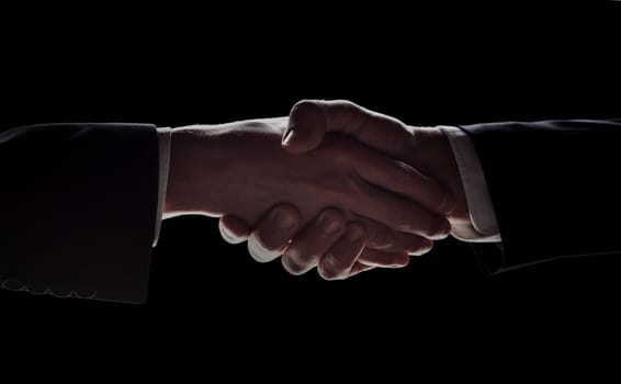 Photo of two men in suits shaking hands on a black background