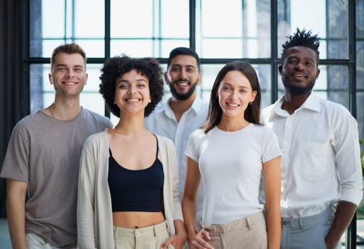 Portrait of successful creative business team looking at camera and smiling. Diverse business people standing together at startup.