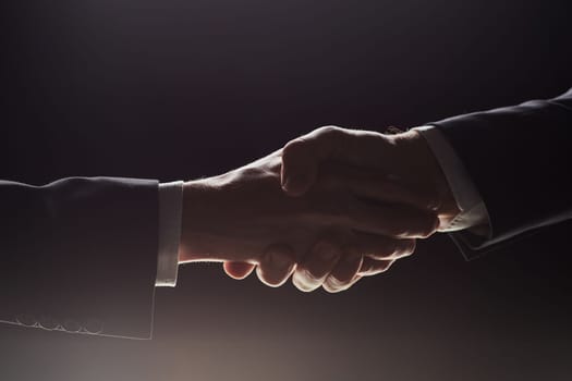 Photo of two men shaking hands on a black background