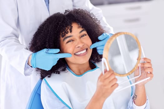 Just brush the teeth you want to keep. a young woman checking her dental work in a mirror