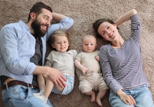 happy family mother father and kids at home. laying