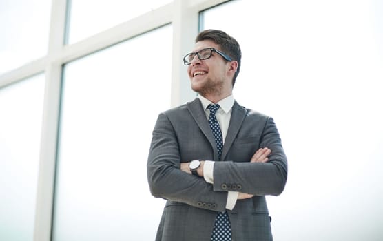 Portrait of a young businessman wearing glasses and standing in office