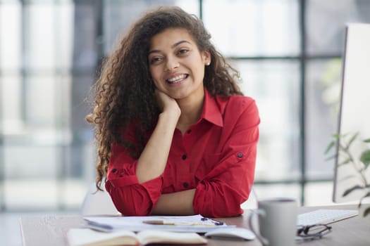 Portrait of Young Successful Caucasian Businesswoman Sitting at Desk Working on Laptop Computer in City Office