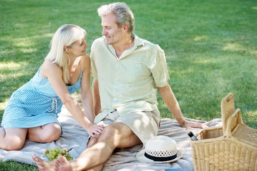 Making the time to keep romance alive. A smiling husband and wife enjoying a leisurely picnic in the park