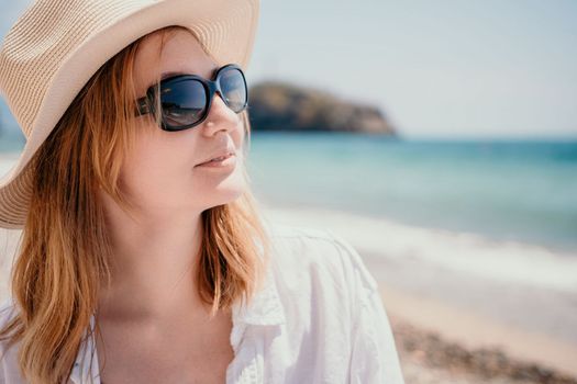Young woman in red bikini on Beach. Blonde in sunglasses on pebble beach enjoying sun. Happy lady in one piece red swimsuit relaxing and sunbathing by turquoise sea ocean on hot summer day. Close up,