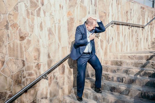 Portrait of a senior professional man in a suit with various problems. A middle-aged businessman with a briefcase descends the stairs.