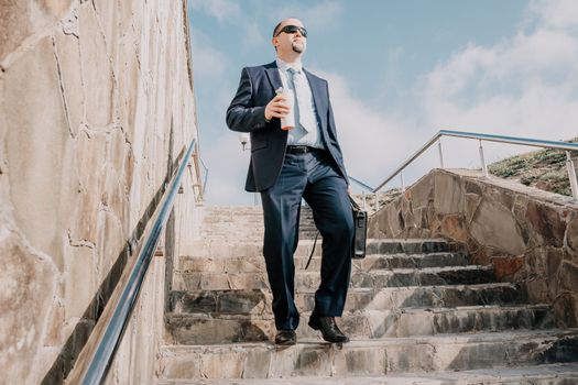 Business executive with briefcase going down the stairs.