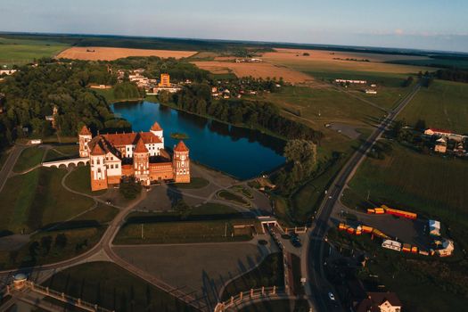 Mir orange castle with spiers near the lake a top view in Belarus in Nesvizh.